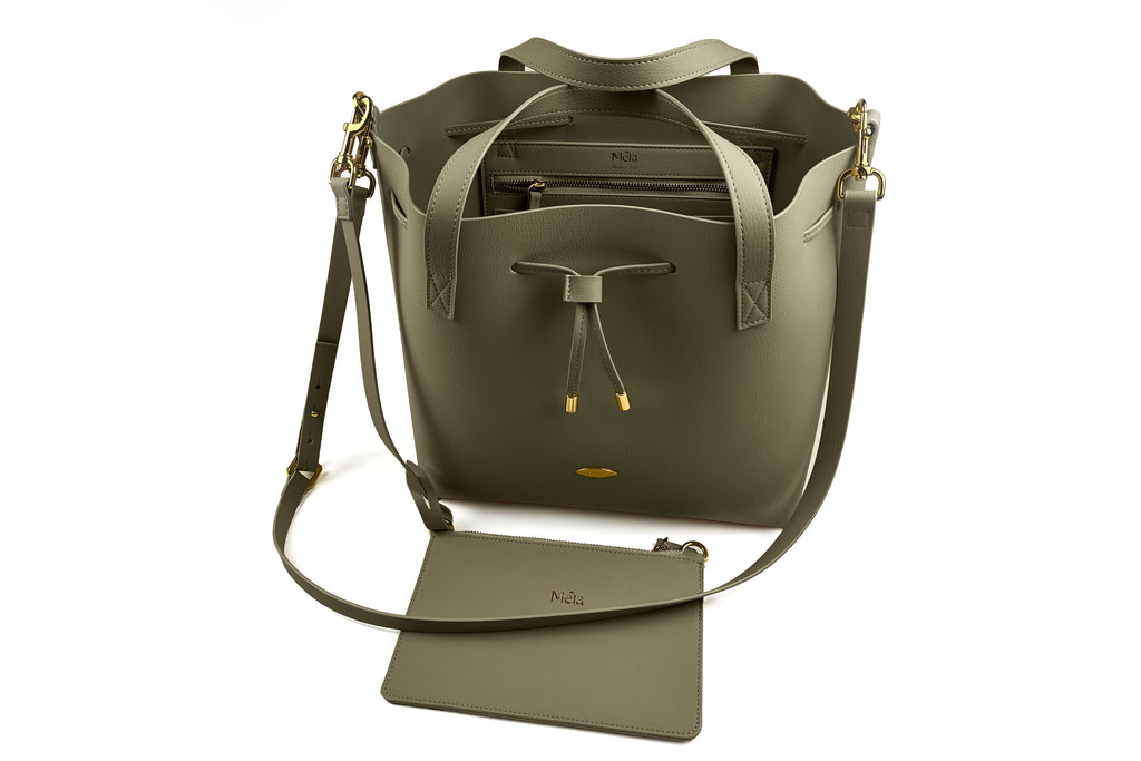 Birdseye view of green leather handbag with matching inner-pouch on a white background